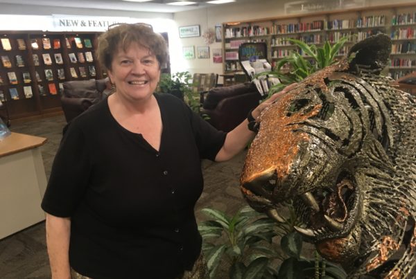 Janet McKenney with tiger sculpture at the Maine State Library